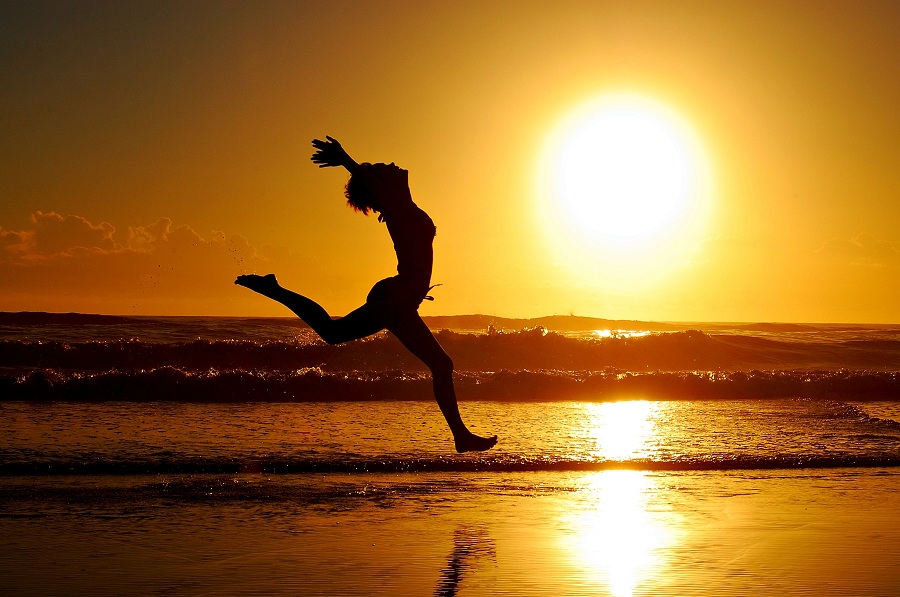 Woman running in the sun alongside a beach