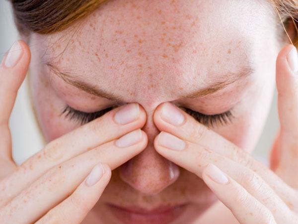 Woman holding her head due to pain
